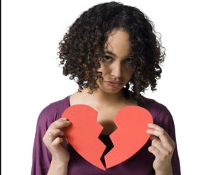 Woman holding broken red heart