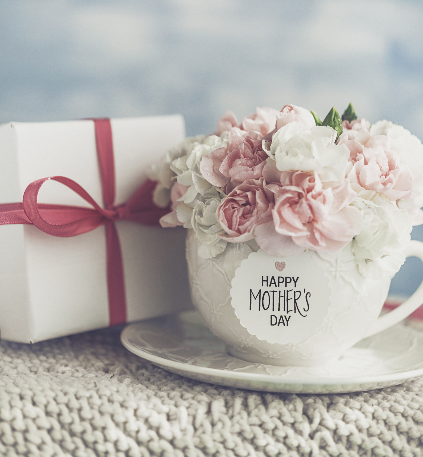 Mother's Day gift and cup filled with fresh carnation bouquet