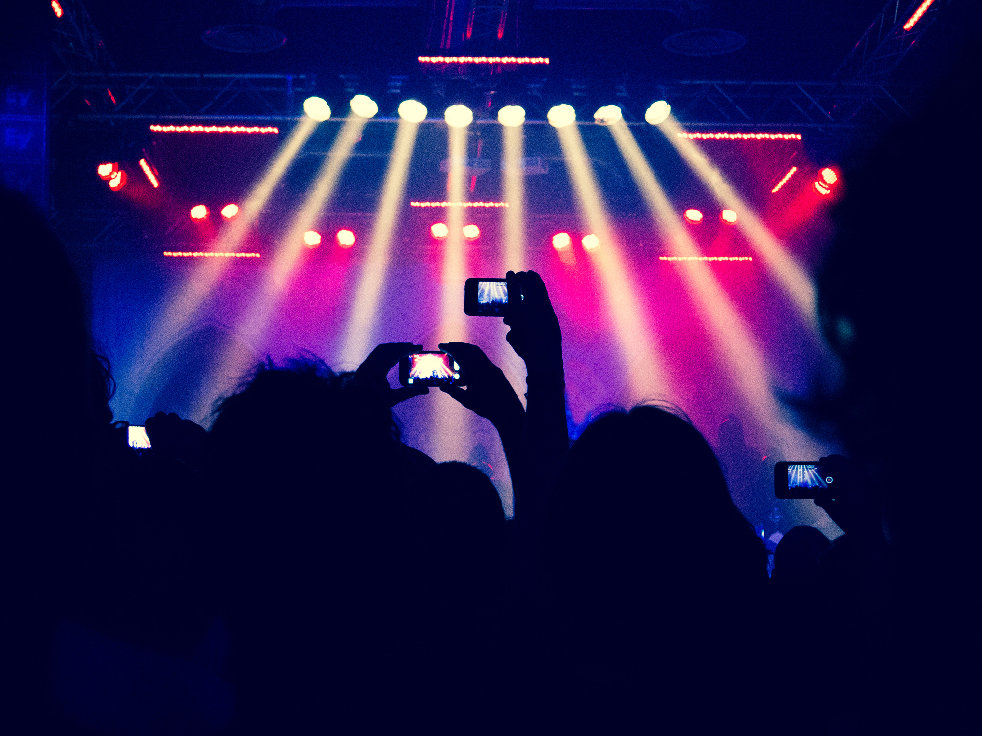 Hands filming a concert