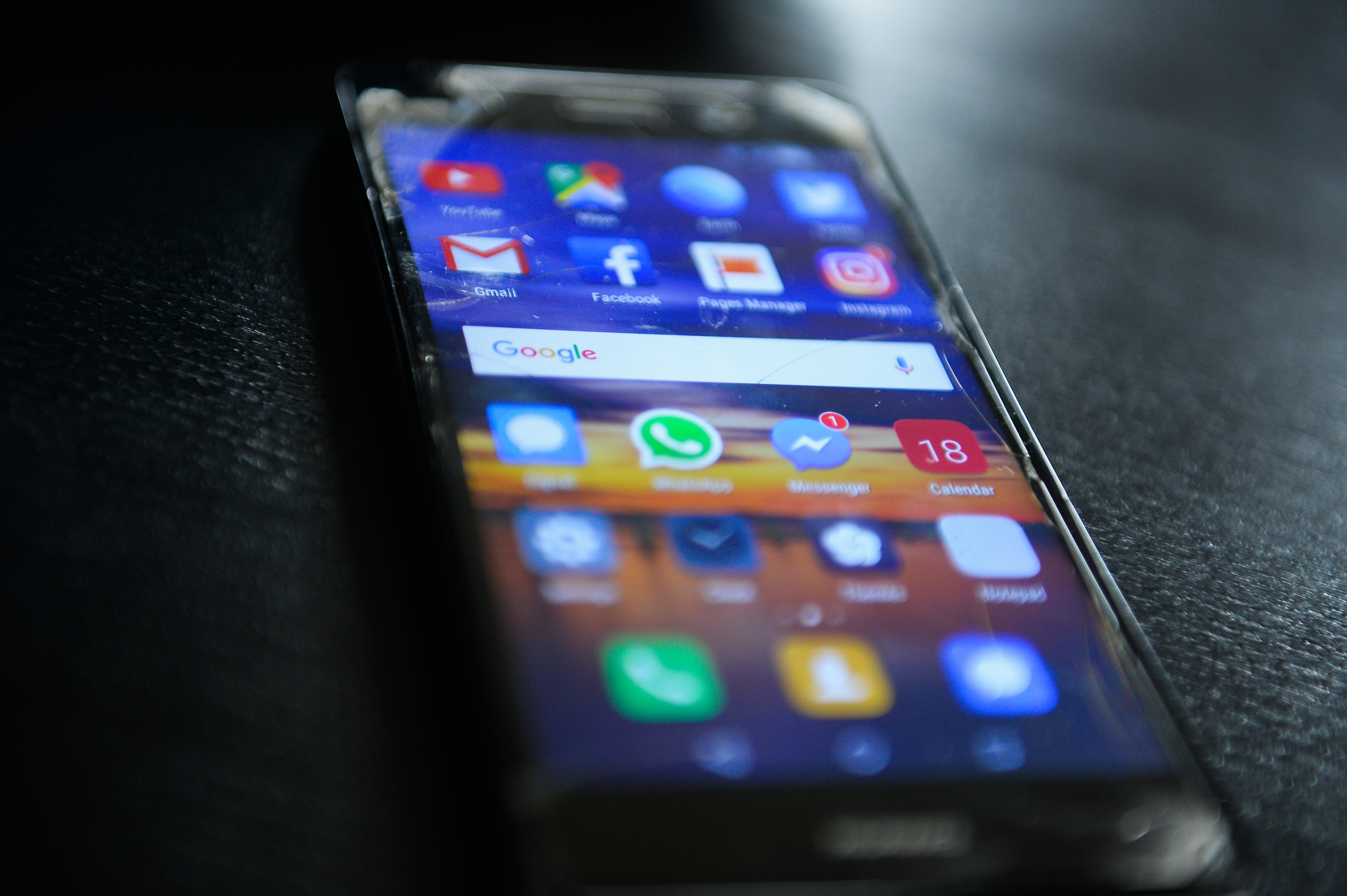 Social media icons are seen in a mobile device...