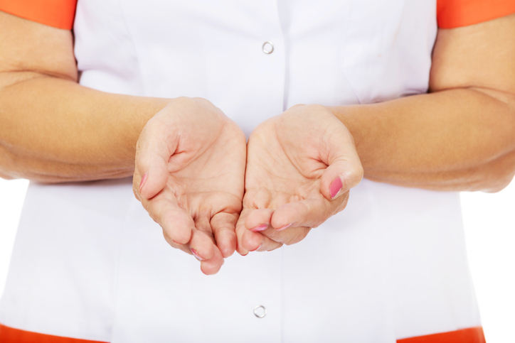 Midsection Of Nurse With Hands Cupped Over White Background