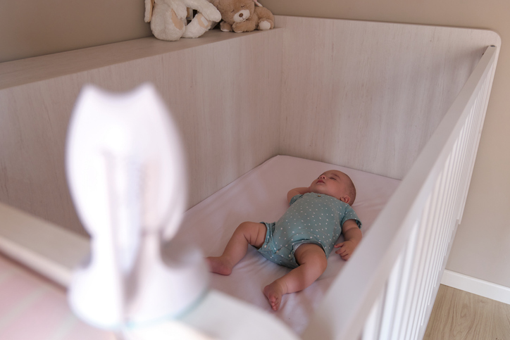 Baby monitor camera watching over a Caucasian baby