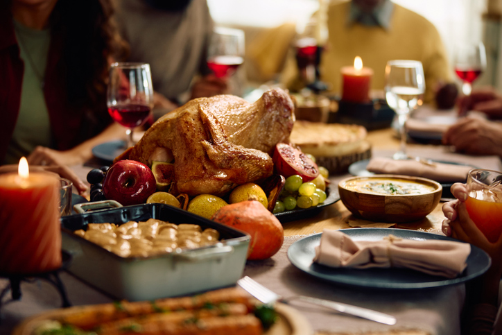 Thanksgiving turkey with family gathered at dining table.